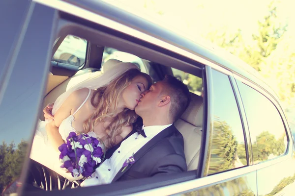 Noiva e noivo beijando no carro — Fotografia de Stock