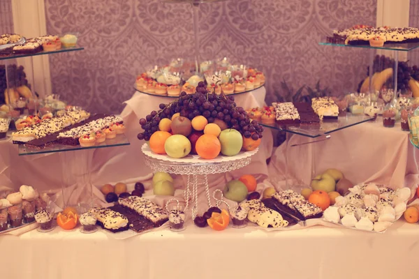 Table with delicious fruits and desserts — Stock Photo, Image