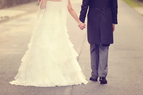 Noiva e noivo andando na estrada — Fotografia de Stock