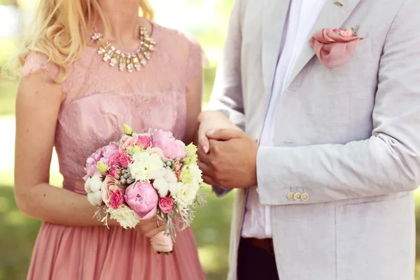 Couple holding hands, Woman with peonies bouquet — Stock Photo, Image