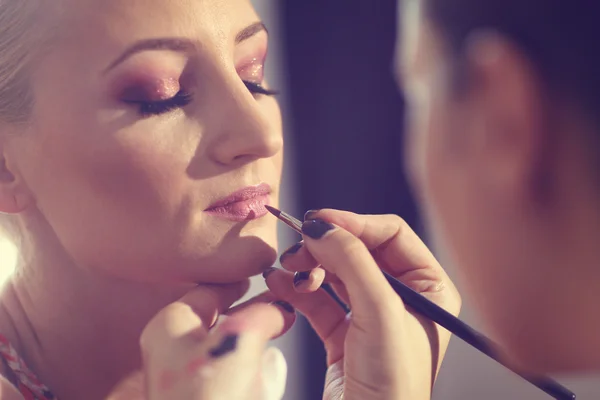 Mooie vrouw met make-up artiest — Stockfoto