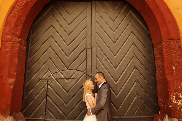 Жених и невеста против большой зеленой двери — стоковое фото