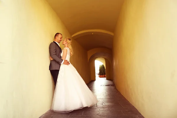 Noiva e noivo em um túnel amarelo — Fotografia de Stock