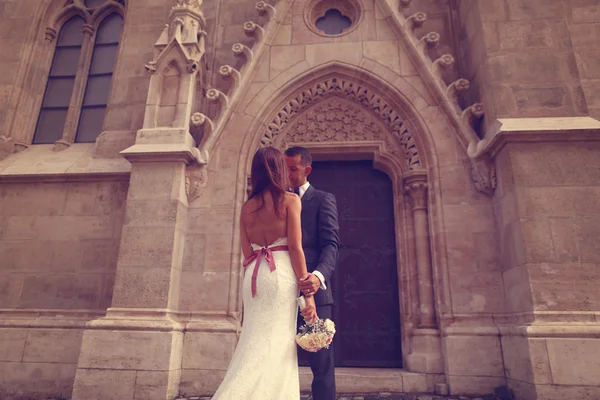 Nevěsta a ženich před kostel — Stock fotografie