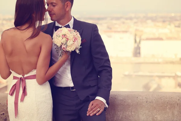 Detalhe de uma noiva e noivo abraçando. Noiva segurando lindo buquê de casamento — Fotografia de Stock