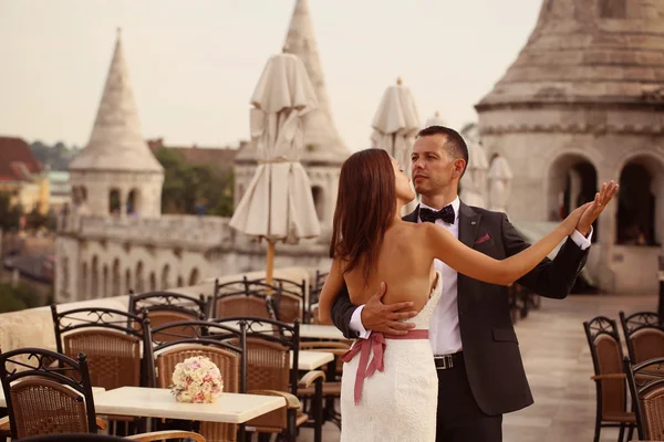 Bride and groom dancing in the top of the city — Stock Photo, Image