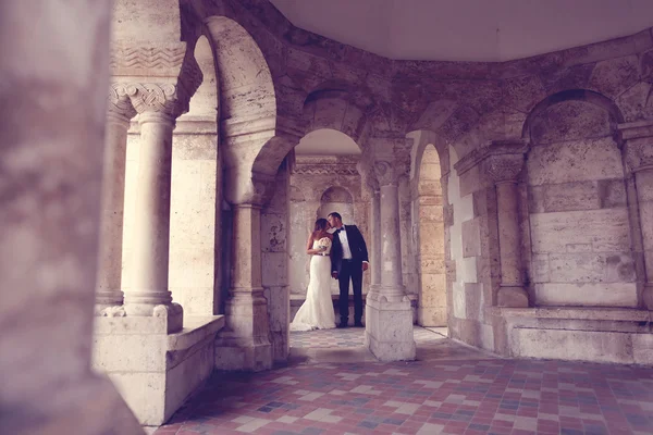 Bruid en bruidegom omringd door prachtige architectuur — Stockfoto