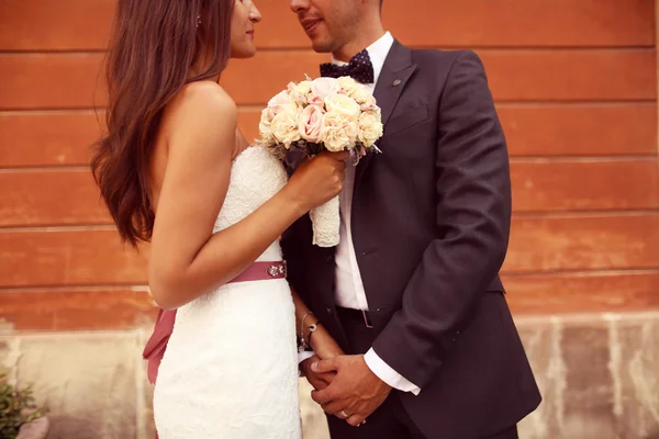 Bride and groom holding hands in the city — Stock Photo, Image