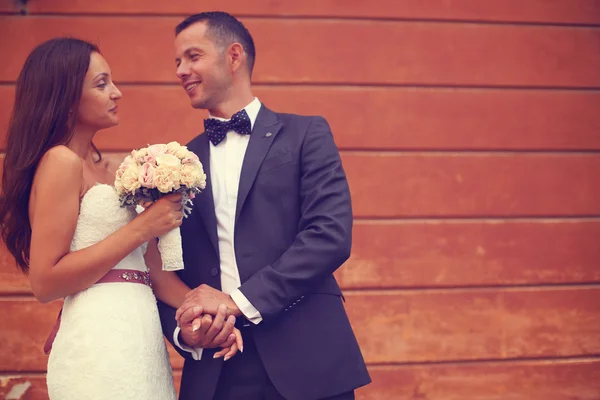 Bride and groom holding hands in the city — Stock Photo, Image