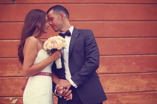 Bruden och brudgummen håller hand i staden — Stockfoto