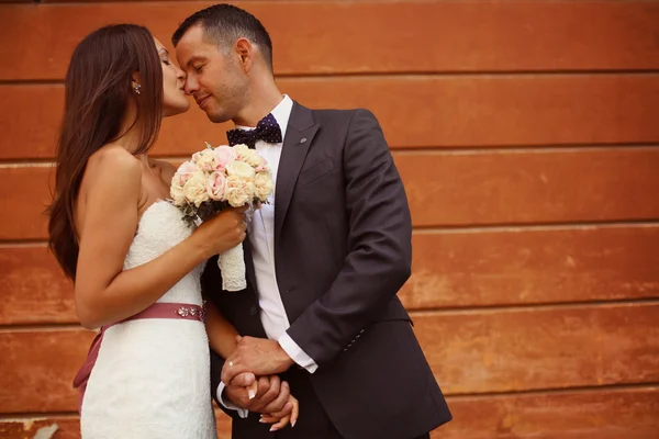 Bruden och brudgummen håller hand i staden — Stockfoto