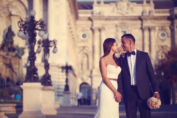 Bruden och brudgummen tittar på varandra i staden — Stockfoto