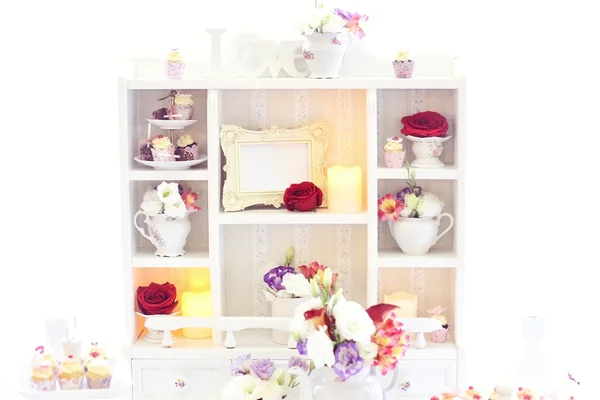 Білий стелаж з квітами і цукерками на весілля — стокове фото