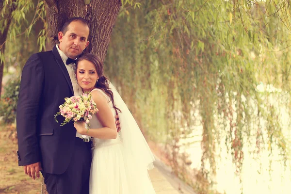 Bride and groom near river — Stock Photo, Image