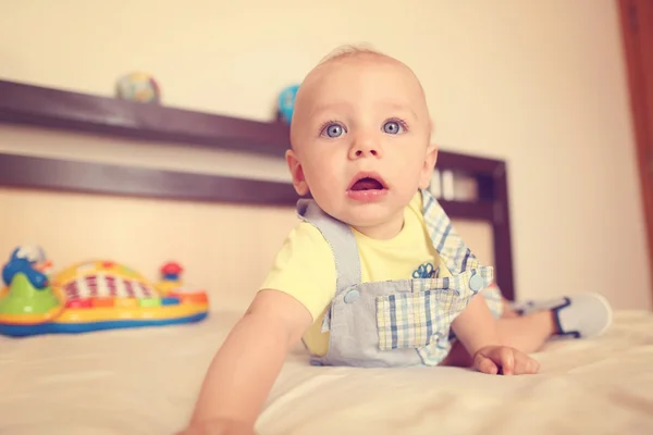 Niño juguetón en su cama —  Fotos de Stock