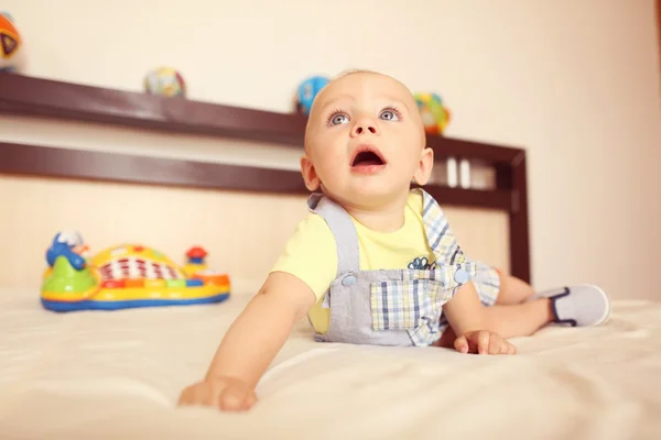 Playful kid in his bed — Stock Photo, Image