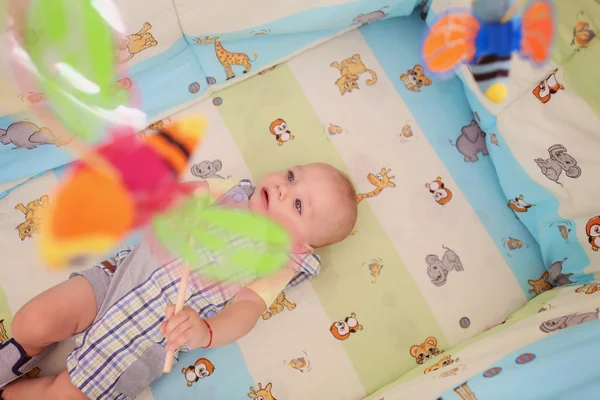 Speelse jong geitje in zijn bed — Stockfoto