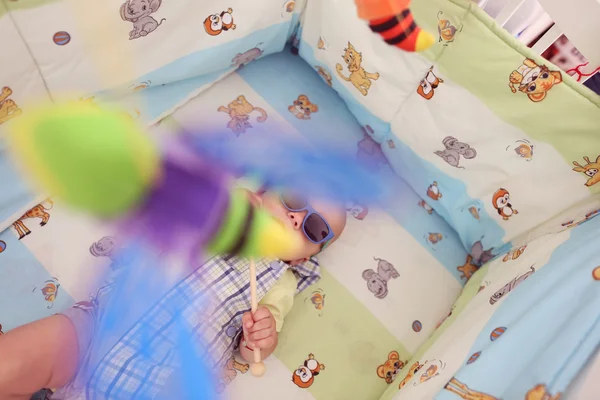 Niño juguetón en su cama con gafas de sol —  Fotos de Stock