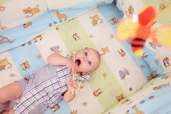Speelse jong geitje in zijn bed — Stockfoto
