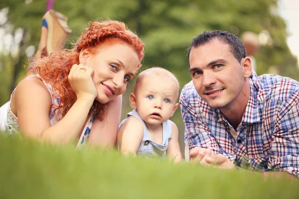Retrato de una familia feliz en el parque — Foto de Stock