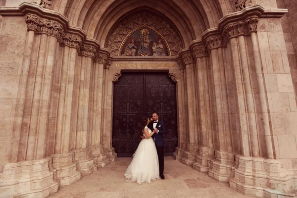 新娘和新郎在教堂前拥抱 — 图库照片