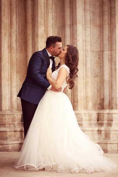 Bride and groom kissing near church — Stock Photo, Image