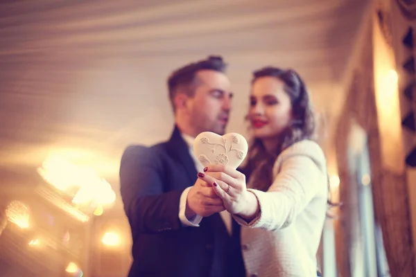 Счастливая пара держит объект в форме сердца — стоковое фото
