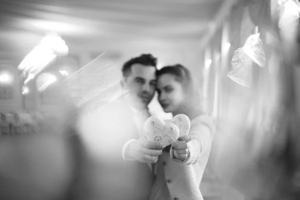 Happy couple holding heart shaped object — Stock Photo, Image