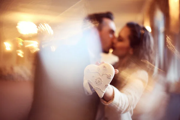 Happy couple holding heart shaped object — Stock Photo, Image