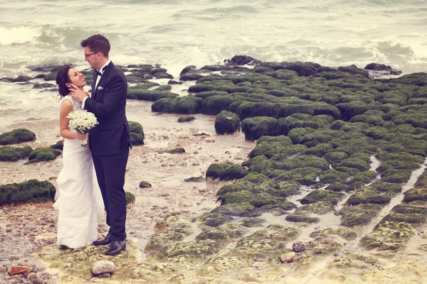 Bride and groom at the ocean — Stock Photo, Image