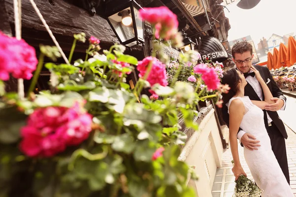 Mariée et marié dans la ville près d'un pot de fleurs — Photo