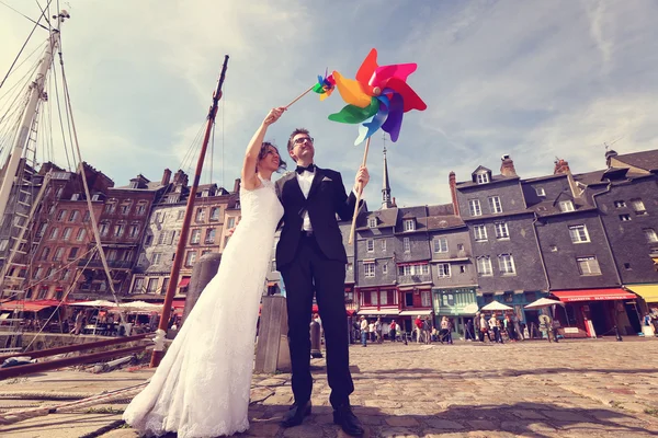 Bruid en bruidegom spelen met windmolen propeller — Stockfoto