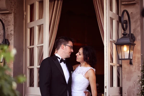 Bride and groom near door with windows — Stock Photo, Image