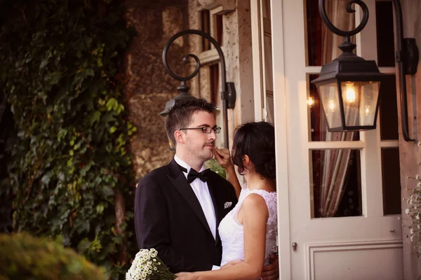 Bride and groom near door with windows — Stock Photo, Image