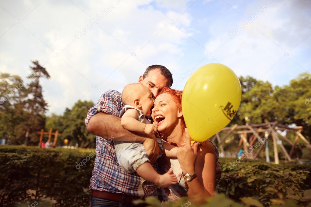 Happy family playing with yellow balloon