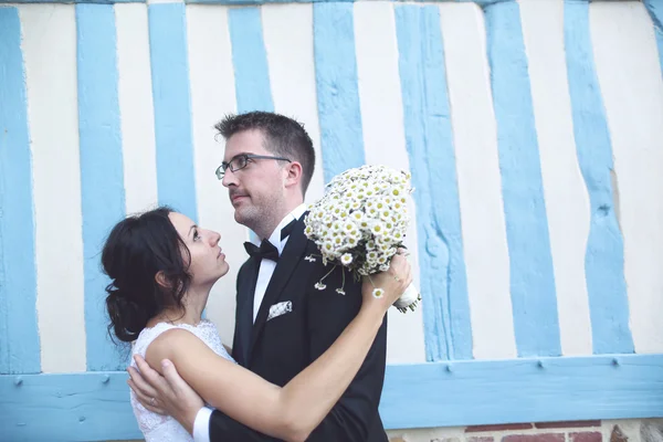 Braut und Bräutigam an einer blau-weiß gestreiften Wand — Stockfoto