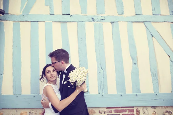 Linda noiva e noivo em uma parede listrada azul e branco — Fotografia de Stock