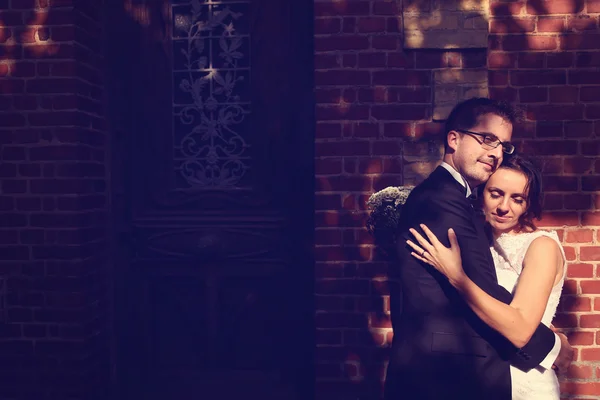 Bride and groom embracing in the sunlight — Stock Photo, Image