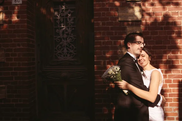 Bride and groom embracing in the sunlight — Stock Photo, Image