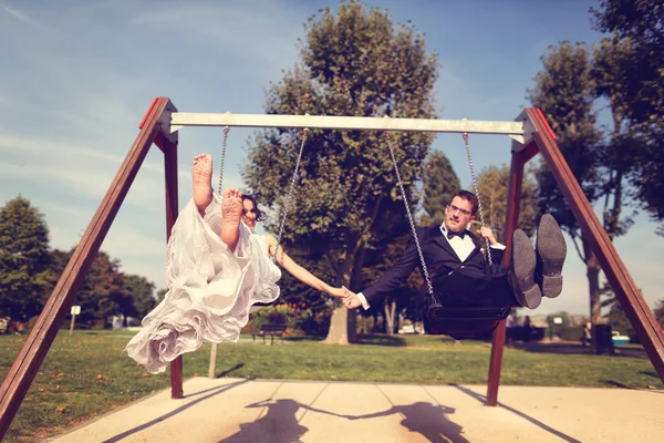 Mariée et marié jouant sur un ensemble de swing — Photo