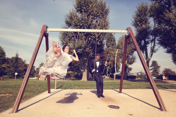 Mariée et marié jouant sur un ensemble de swing — Photo