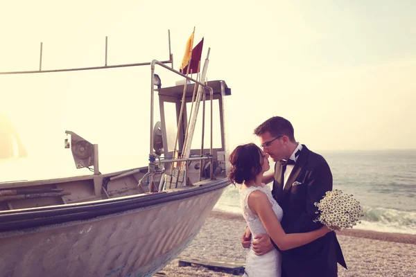 Bride and groom near big boat at shore — Stock Photo, Image