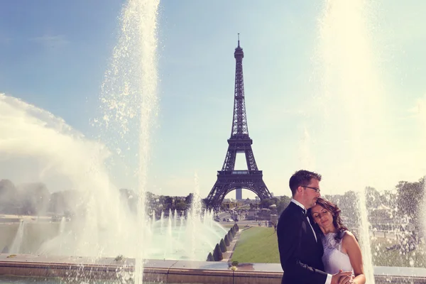 Mariée et marié étreignant à la fontaine à Paris — Photo