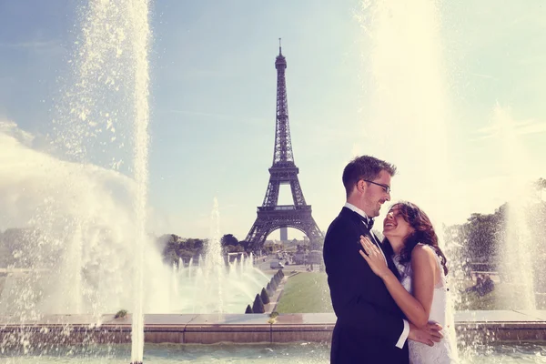 Bruden och brudgummen kramas vid fontänen i Paris — Stockfoto