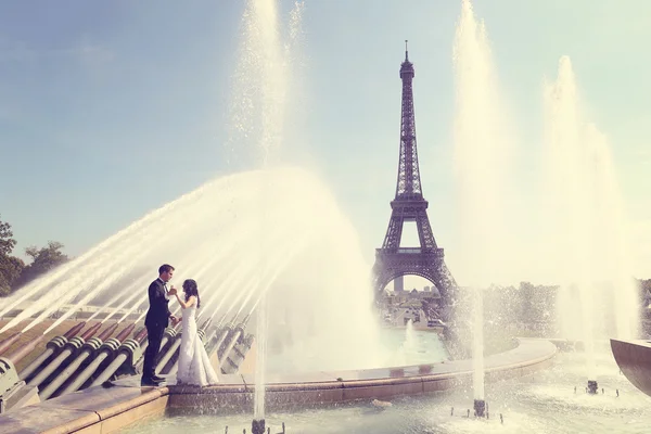 Braut und Bräutigam amüsieren sich am Brunnen in Paris — Stockfoto
