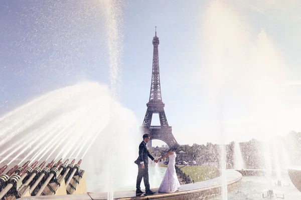 Braut und Bräutigam amüsieren sich am Brunnen in Paris — Stockfoto