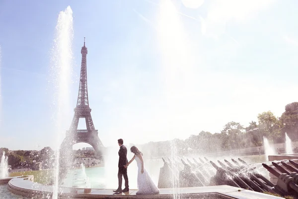 Bride and groom having fun at fountain in Paris — Stock Photo, Image