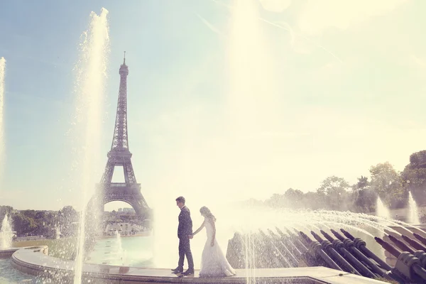 Bride and groom having fun at fountain in Paris — Stock Photo, Image