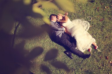 Gelin ve damat çim üzerinde yalan