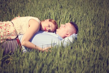 Güzel çift yeşil çim üzerinde yalan